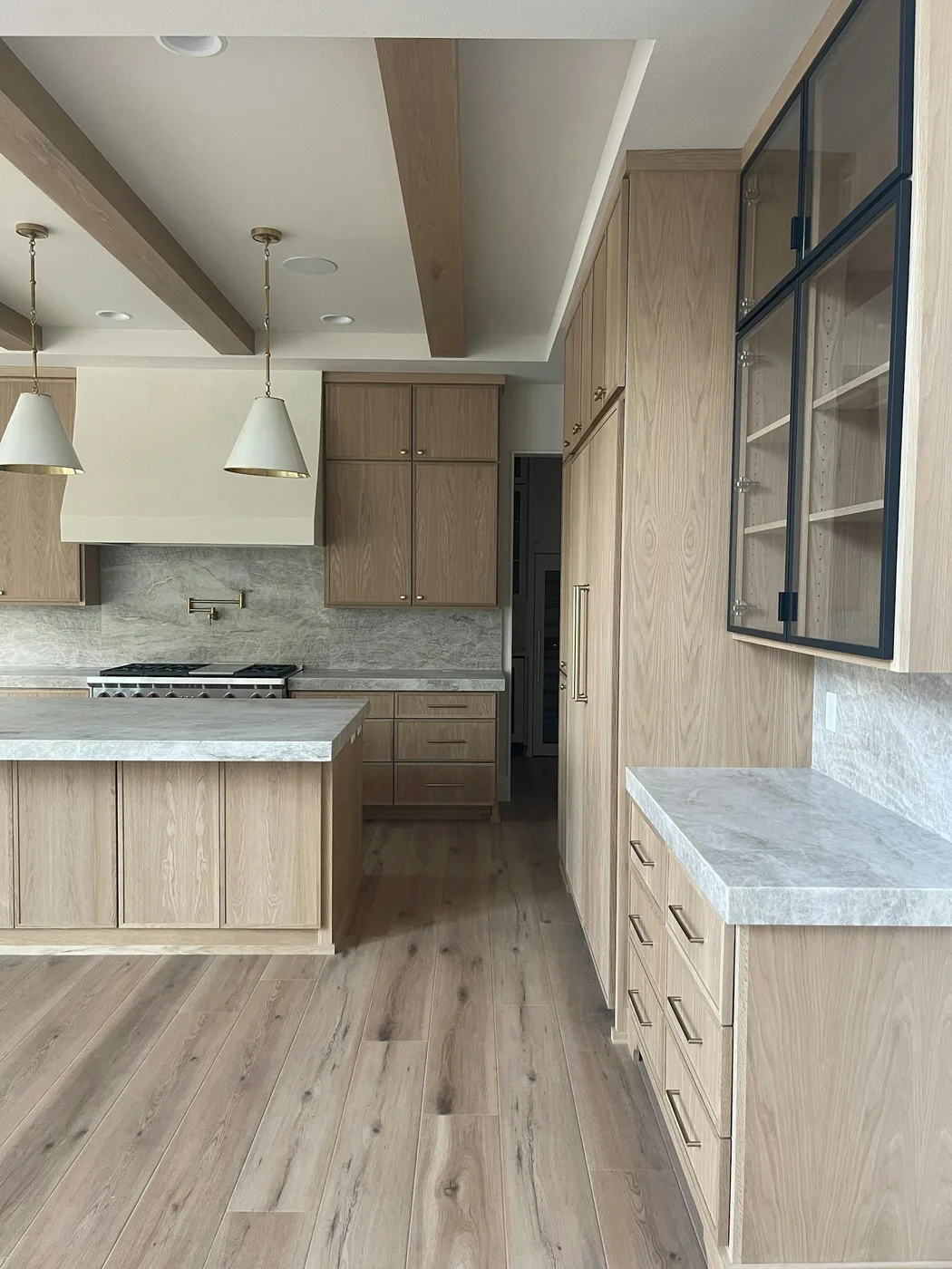 Bright home interior with wood cabinetry and marble counters